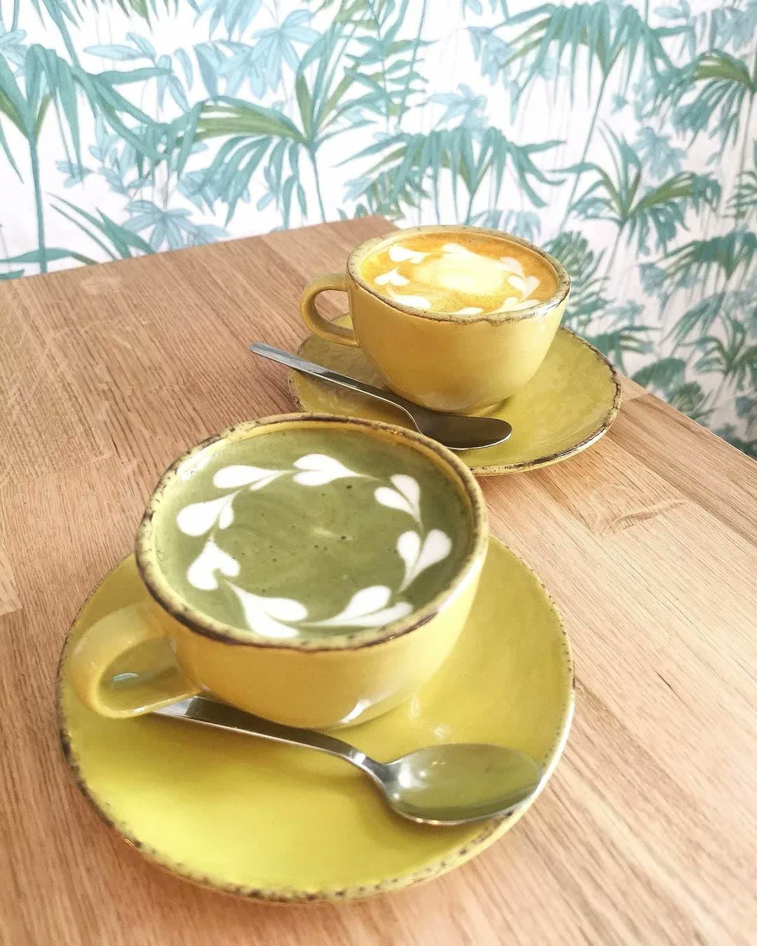 Deux lattes de Cabane, matcha et curcuma, sur une table en bois