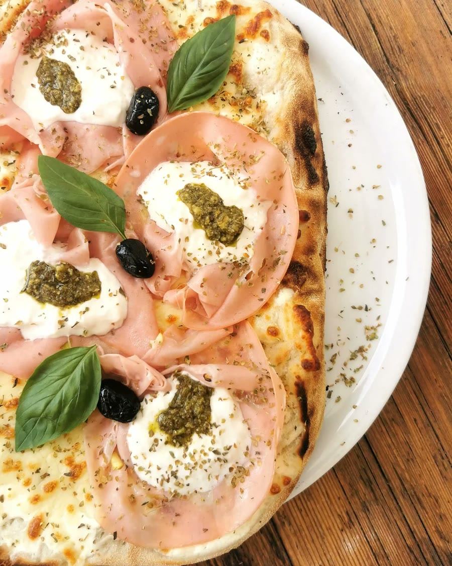 Une pinsa à la mortadelle, stracciatella et pesto servie à La Maison