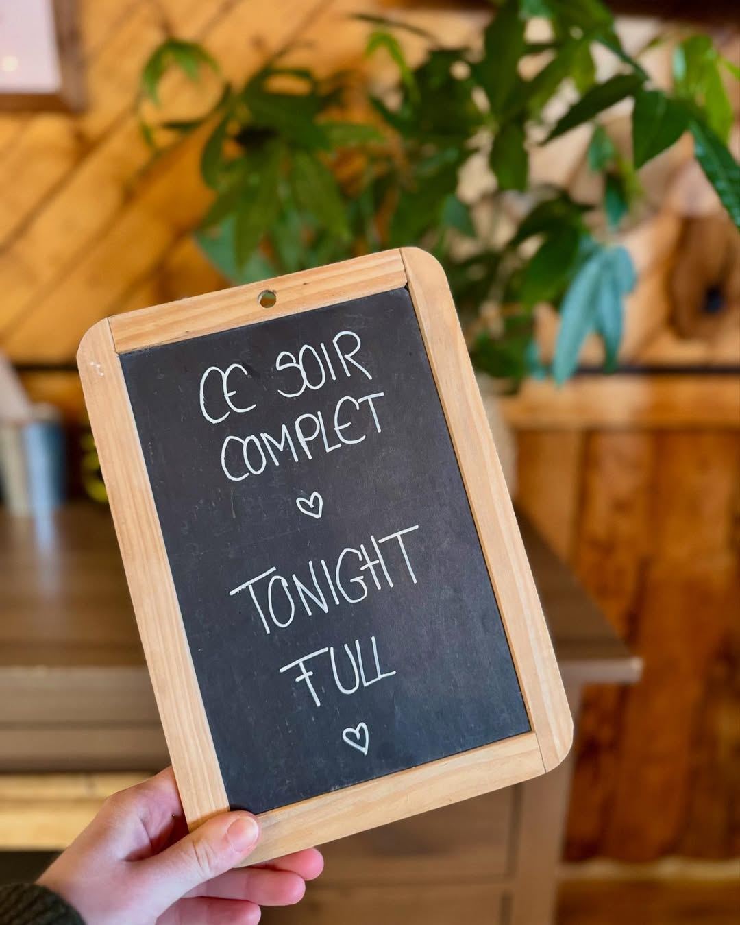 L’ardoise « Ce soir complet, tonight full » tenue à la main dans La Maison