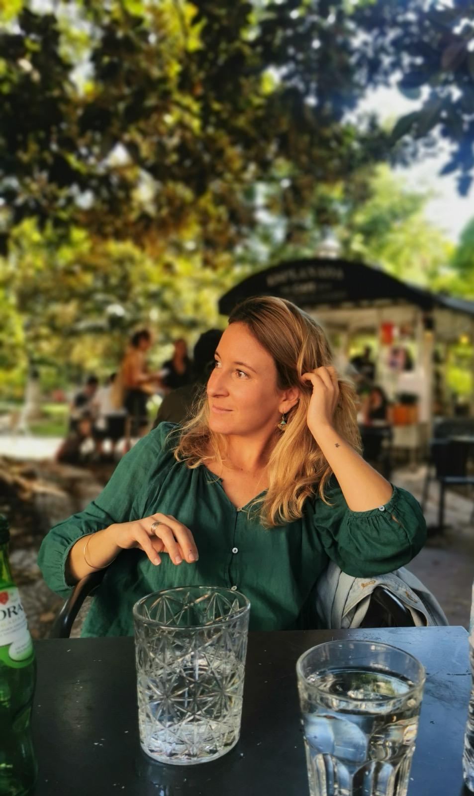 Laure Gasquet, en vert, attablée dans un jardin