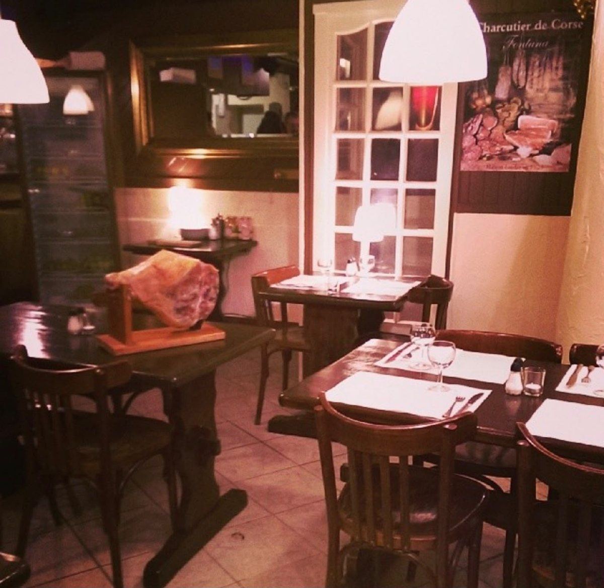 La salle d’un restaurant le soir, tables dressées et lumière douce