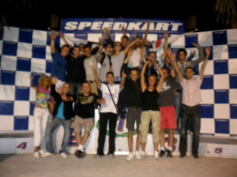Une équipe de saison réunie devant le damier d’un circuit de karting