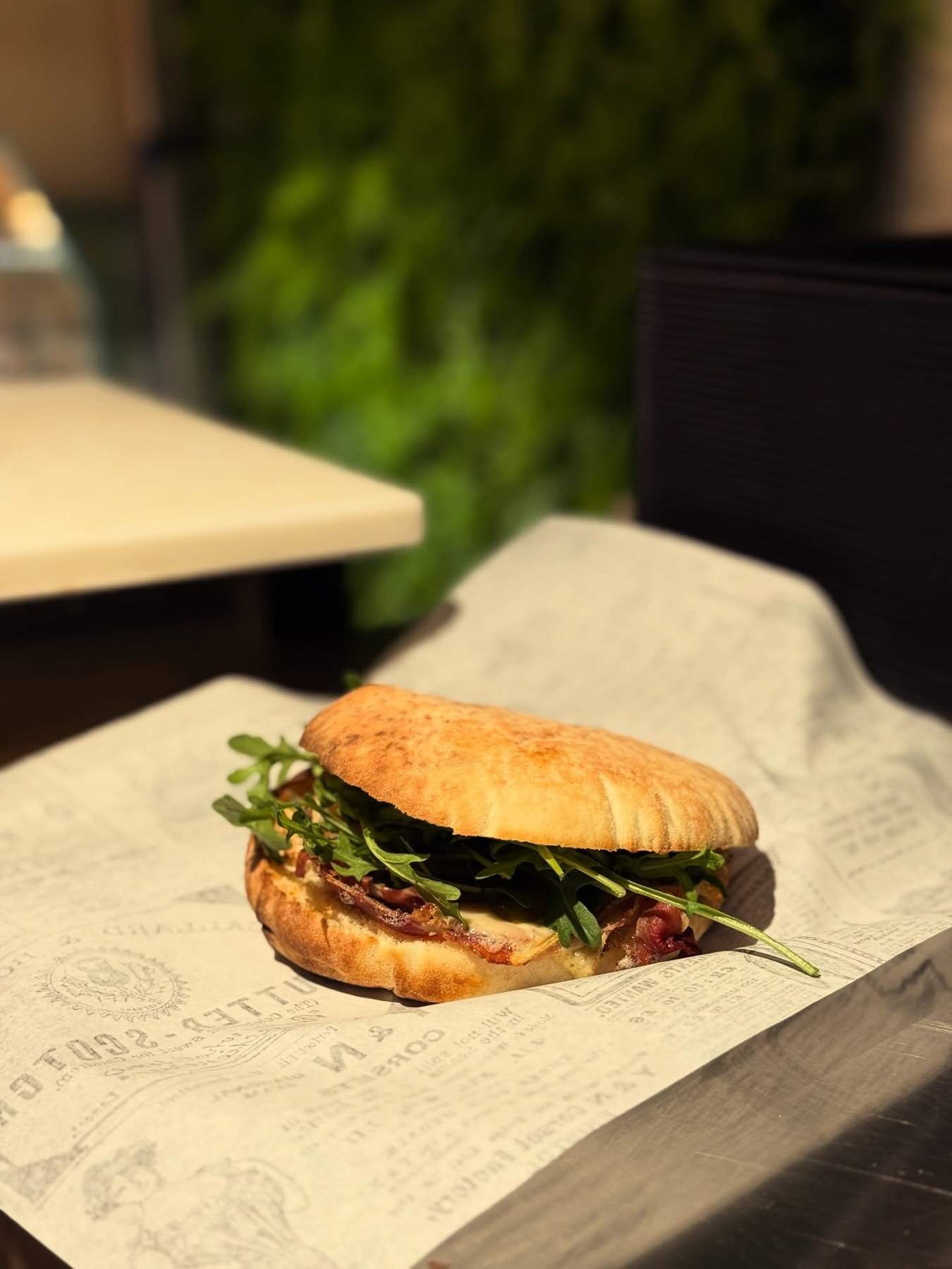 La puccia raclette de Saveur Alpine, roquette et fromage fondu, sur son papier imprimé