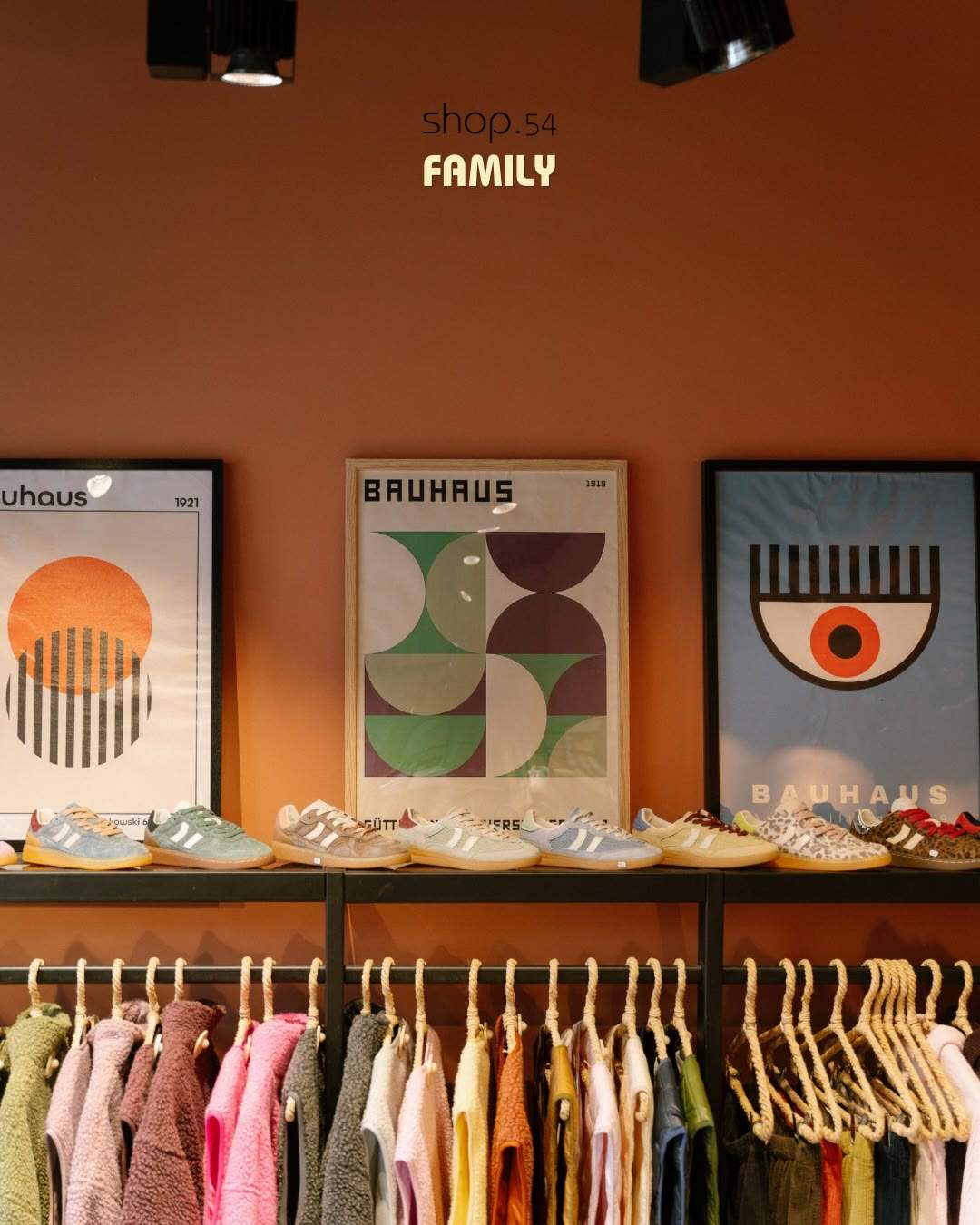La boutique Family de Shop 54 : affiches Bauhaus, baskets alignées et portants de couleurs