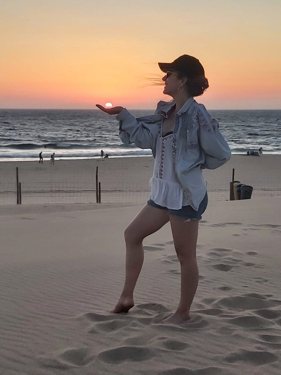 Laure sur une plage au coucher du soleil, en veste en jean