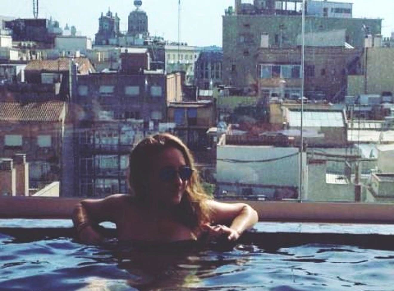 Laure dans une piscine sur un toit, face aux immeubles d’une grande ville